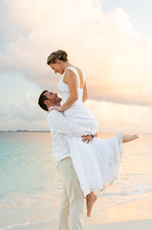 Carribbean Paradise Aurora Anguilla Resort and Golf Club couple on beach wedding lifting in air