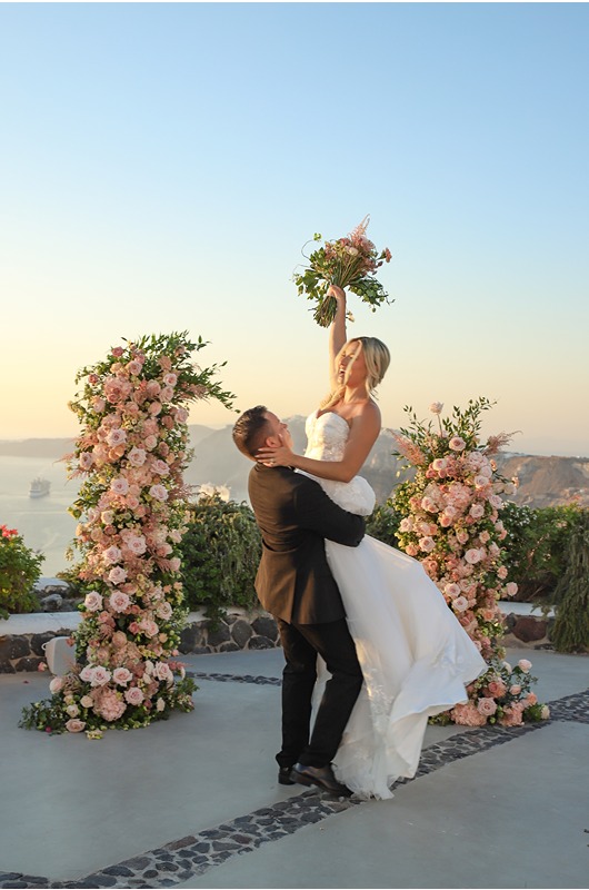 Santorini Wedding Style Intimate Morning Shoot And Sunset Elopement groom lifts up bride